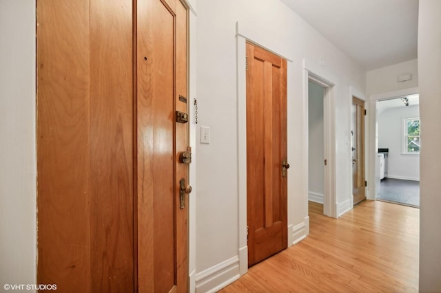 hall with light wood-type flooring and baseboards