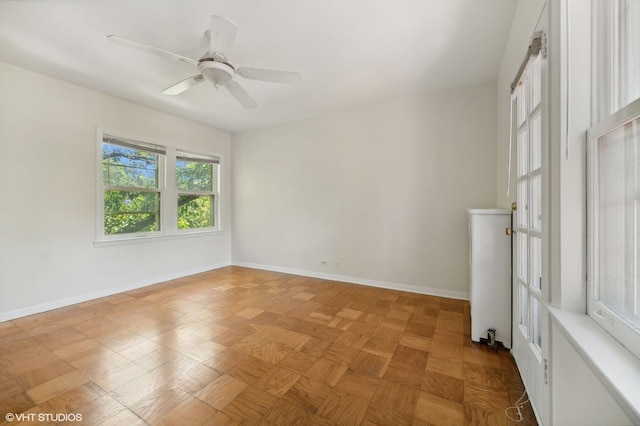 unfurnished room featuring ceiling fan and baseboards