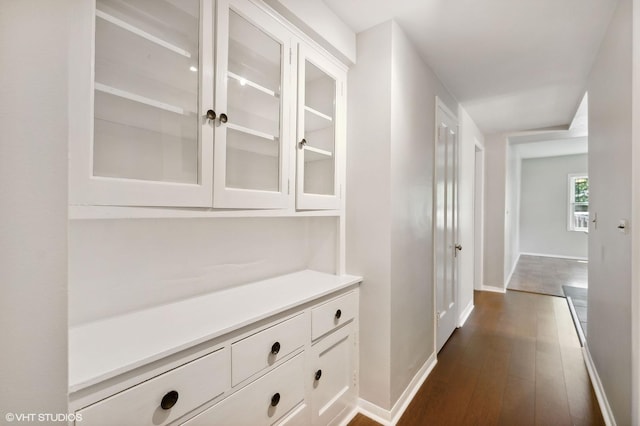 hallway with baseboards and dark wood finished floors