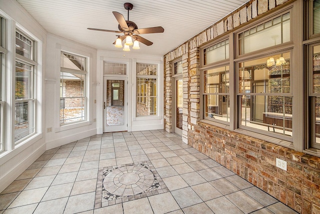 unfurnished sunroom with ceiling fan
