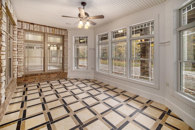unfurnished sunroom featuring ceiling fan