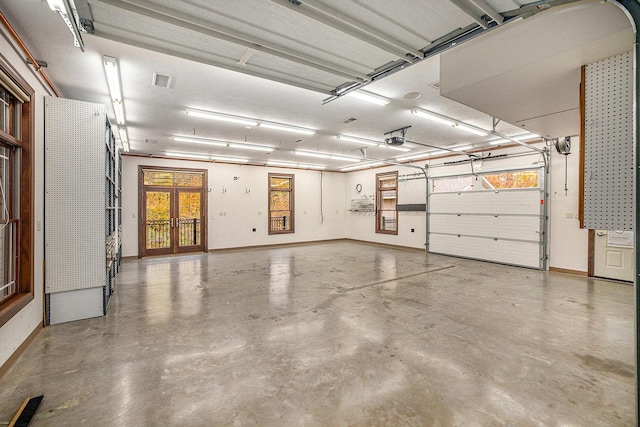 garage with baseboards, visible vents, and a garage door opener