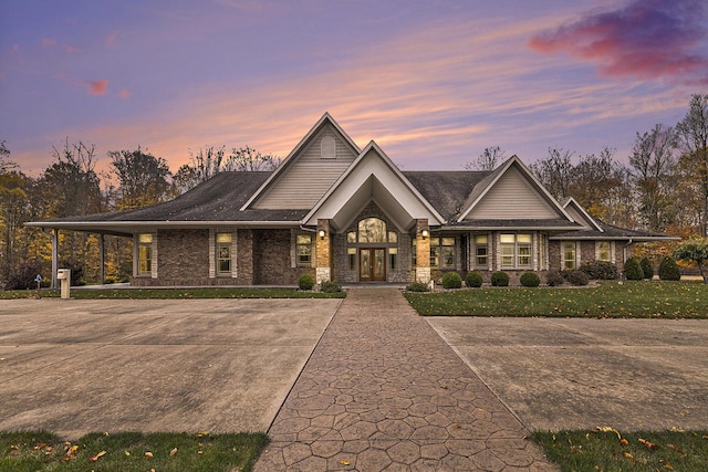 view of front of home with brick siding and a lawn