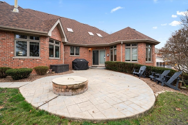 back of property featuring an outdoor fire pit and a patio