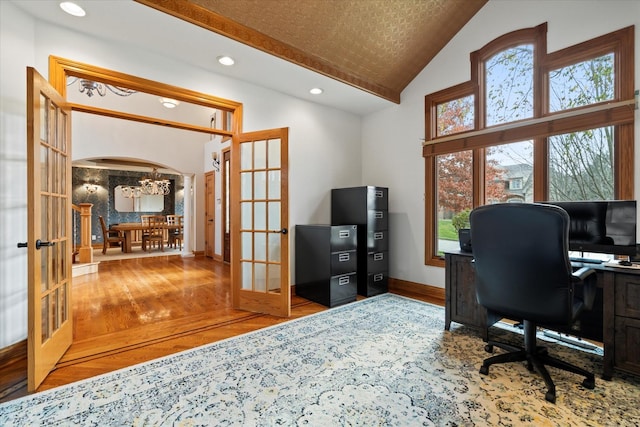 office area with vaulted ceiling, hardwood / wood-style floors, a notable chandelier, and french doors