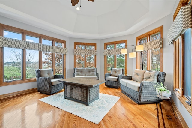 sunroom / solarium with a tray ceiling and ceiling fan