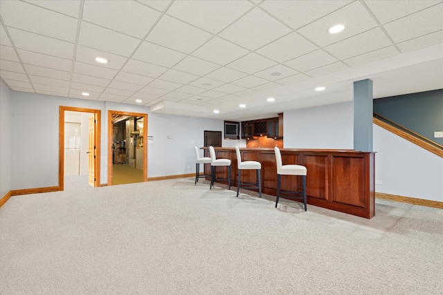 bar featuring light colored carpet and a drop ceiling