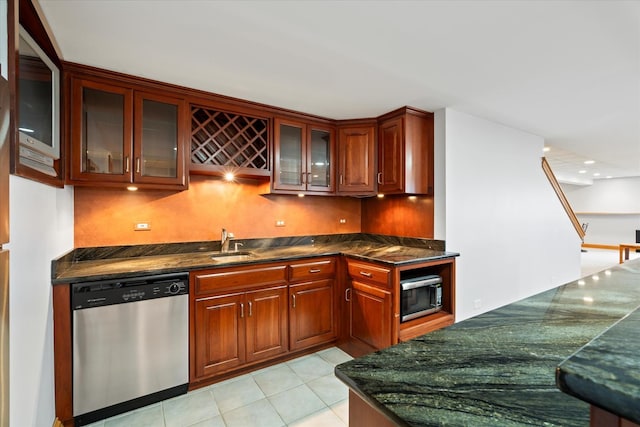 kitchen with dark stone countertops, appliances with stainless steel finishes, and light tile patterned floors