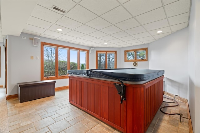 interior space featuring a paneled ceiling and a jacuzzi