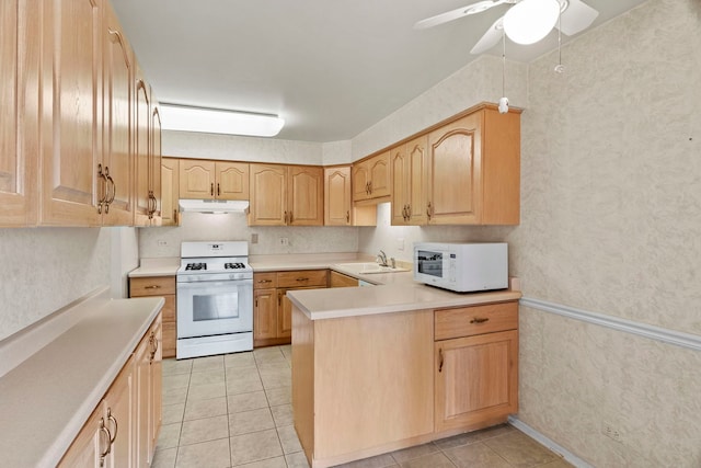 kitchen featuring white appliances, light countertops, under cabinet range hood, and light brown cabinets