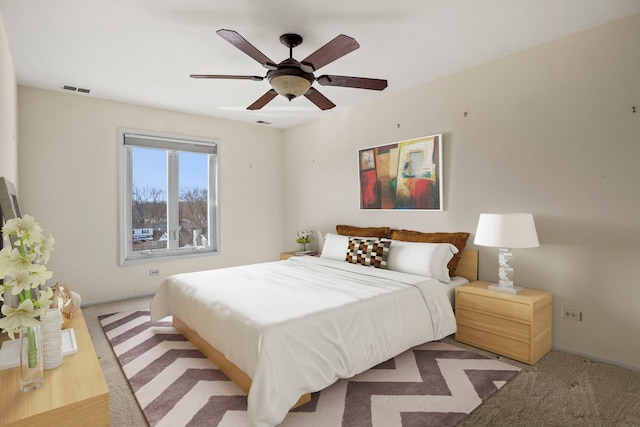 bedroom with light carpet, ceiling fan, visible vents, and baseboards