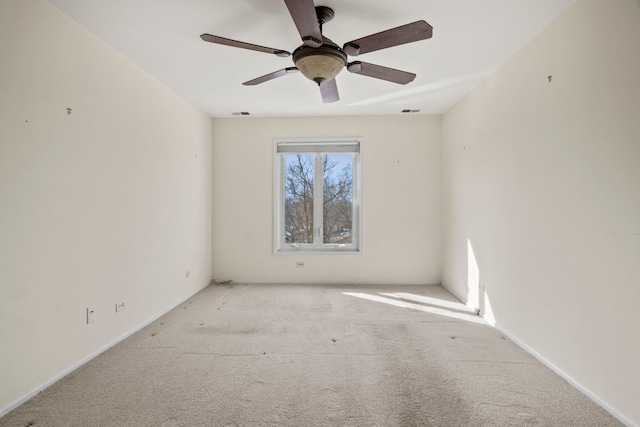 spare room featuring a ceiling fan, light carpet, and visible vents