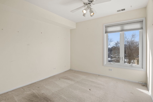 unfurnished room with a ceiling fan, visible vents, and light colored carpet