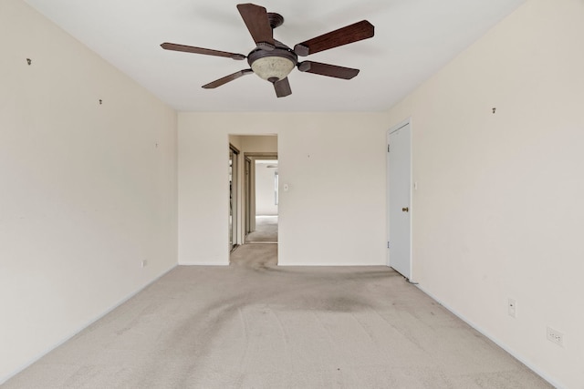 unfurnished room featuring light carpet, ceiling fan, and baseboards