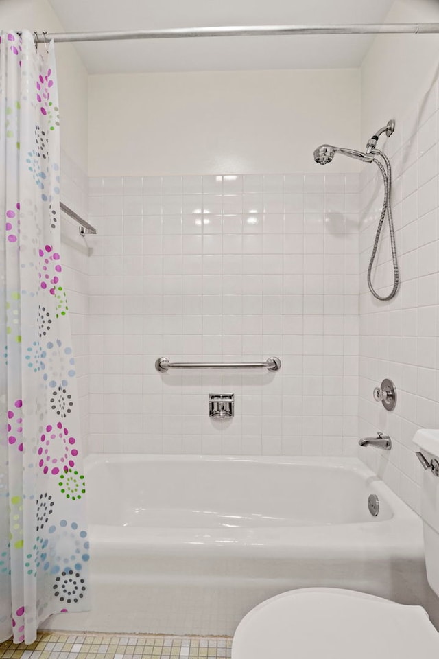 full bathroom featuring shower / bath combination with curtain and toilet