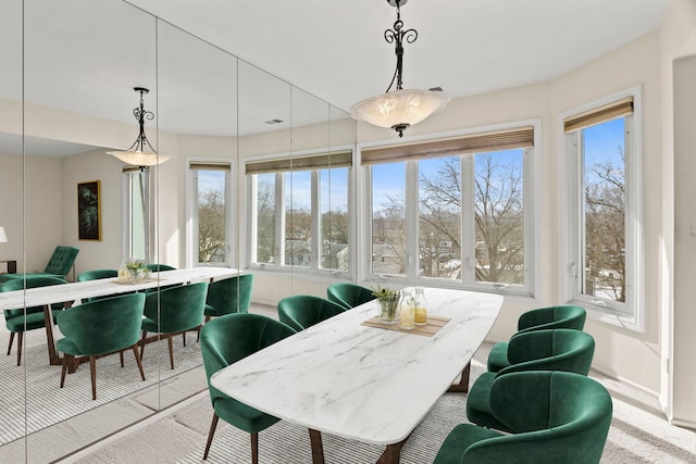 dining area with light carpet and baseboards