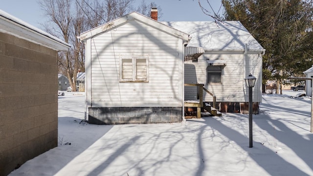 view of snow covered back of property