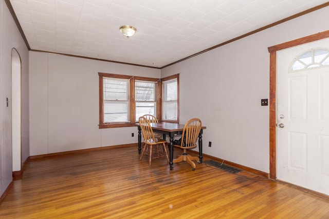 dining area featuring crown molding, plenty of natural light, and hardwood / wood-style floors