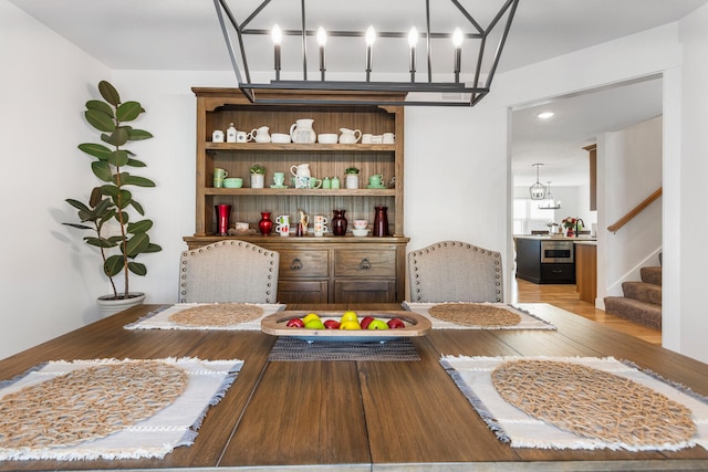 dining space with light wood-type flooring and stairway