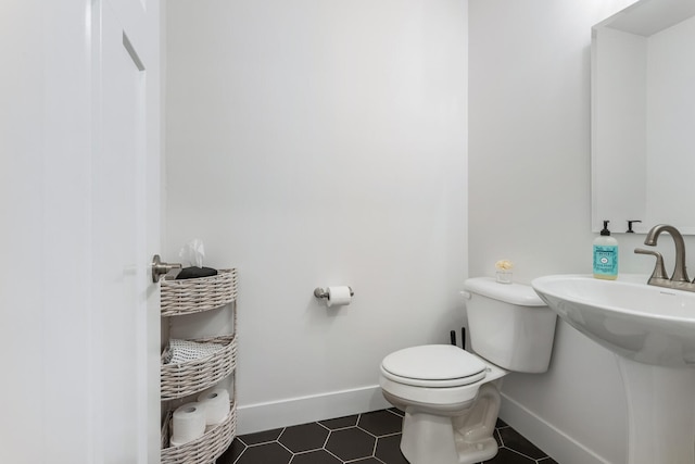 bathroom with tile patterned flooring, toilet, and baseboards