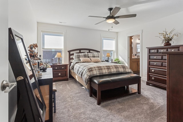 carpeted bedroom featuring connected bathroom and a ceiling fan