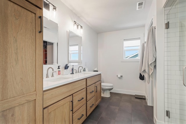 bathroom with toilet, a stall shower, visible vents, and a sink