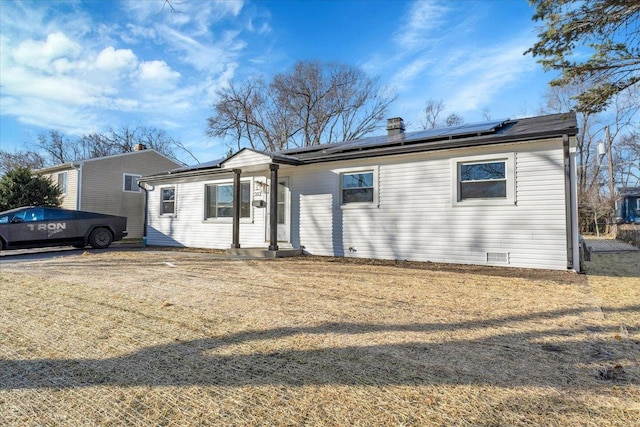 ranch-style house featuring a front yard and solar panels