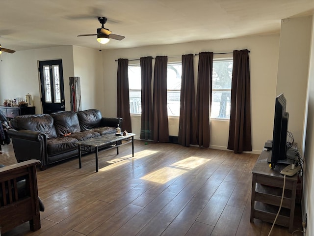 living room featuring ceiling fan, wood finished floors, and baseboards