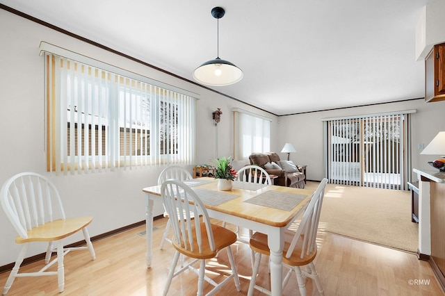 dining area featuring light wood-style flooring and baseboards