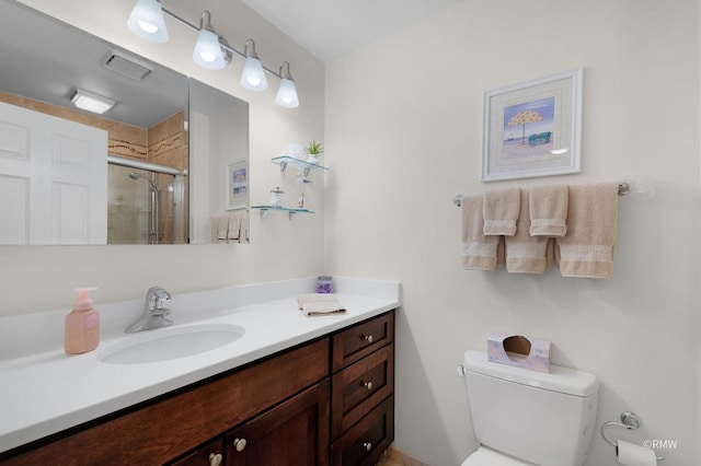 full bath with toilet, a tile shower, and vanity