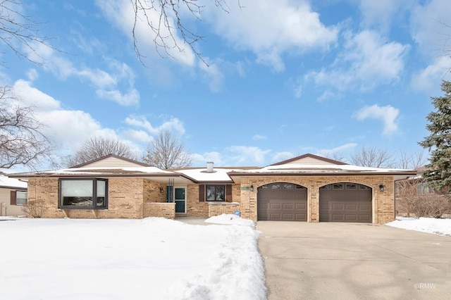 single story home featuring a garage, concrete driveway, and brick siding