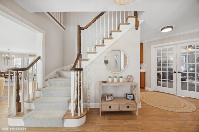 stairs featuring baseboards, ornamental molding, wood finished floors, an inviting chandelier, and french doors