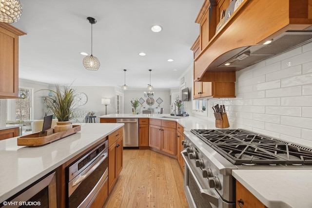 kitchen featuring stainless steel appliances, light countertops, and decorative light fixtures