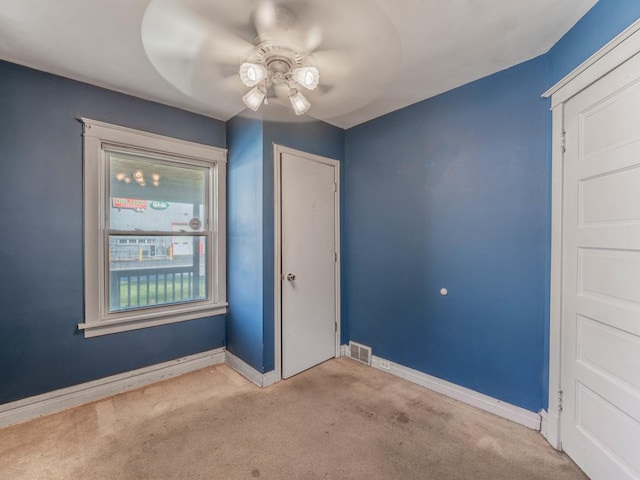 empty room with ceiling fan and light colored carpet