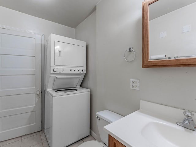 laundry room featuring sink, light tile patterned flooring, and stacked washer / dryer