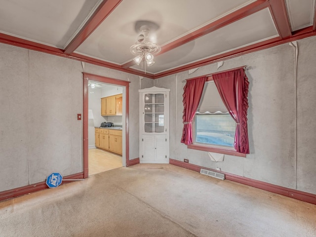 empty room with crown molding, light colored carpet, and ceiling fan