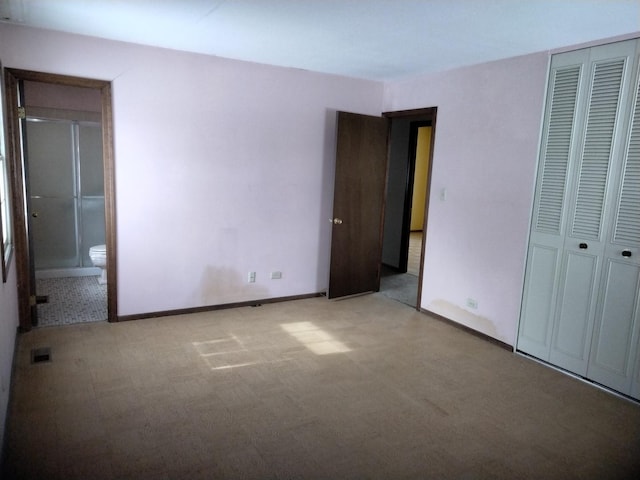 unfurnished bedroom featuring a closet, visible vents, light colored carpet, and baseboards