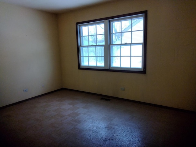 spare room featuring visible vents and baseboards