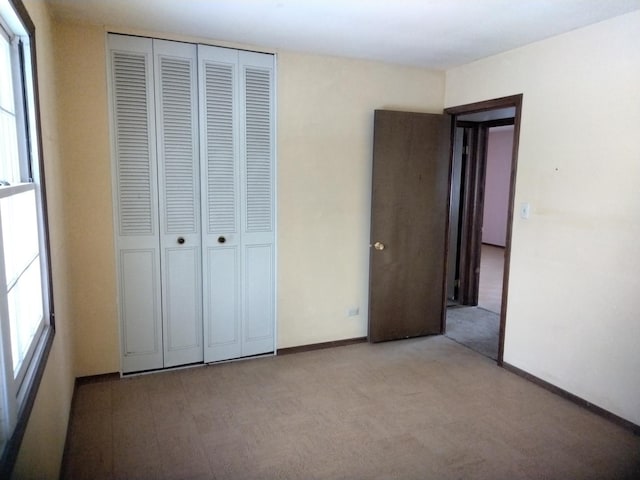 unfurnished bedroom with a closet and baseboards