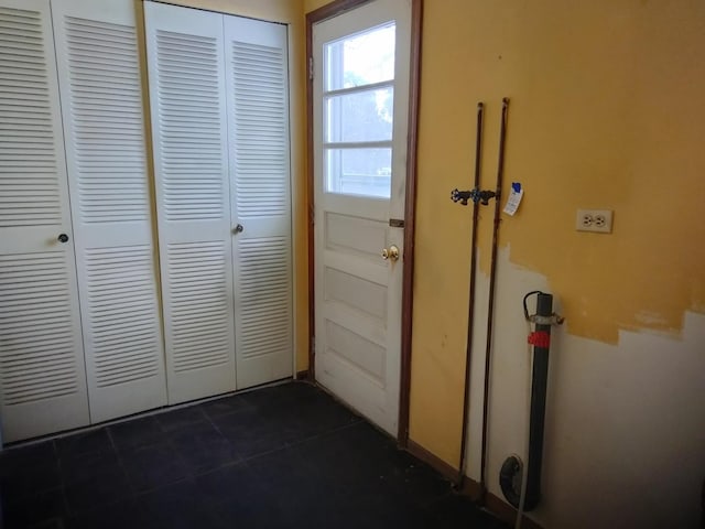 entryway featuring dark tile patterned floors