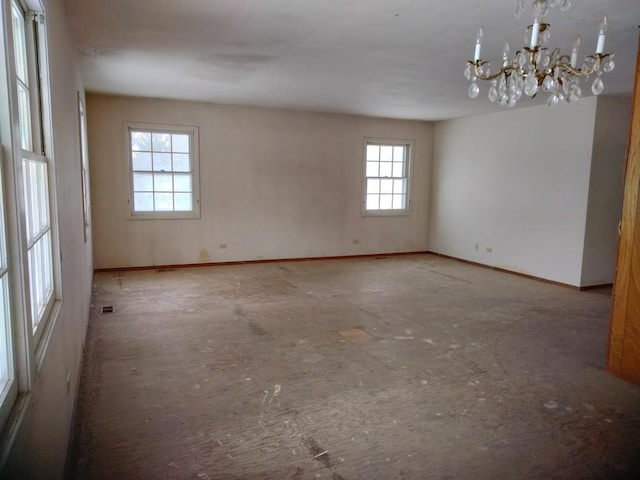 empty room featuring a chandelier, visible vents, and baseboards