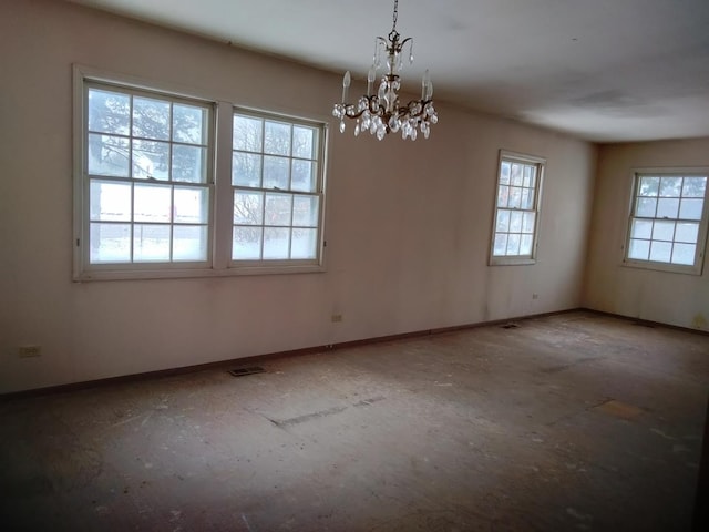 spare room featuring an inviting chandelier, baseboards, and visible vents