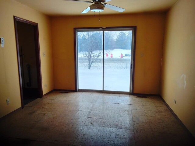 spare room with light floors, baseboards, and ceiling fan