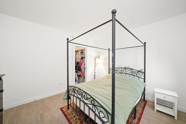 bedroom featuring a spacious closet and hardwood / wood-style floors