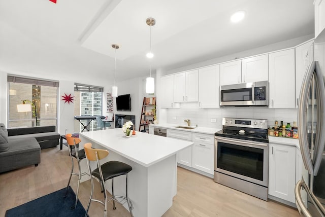 kitchen featuring white cabinetry, sink, pendant lighting, and stainless steel appliances