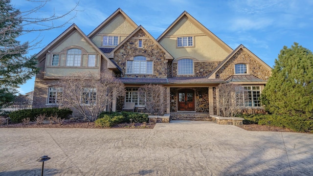 view of front of house featuring stone siding and stucco siding