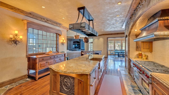 kitchen featuring light stone counters, backsplash, dark wood finished floors, range with two ovens, and baseboards