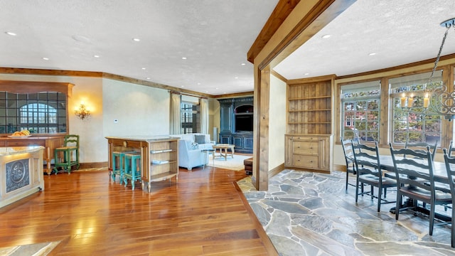 dining room featuring baseboards, ornamental molding, recessed lighting, a textured ceiling, and wood-type flooring