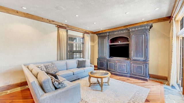 living area with baseboards, a textured ceiling, and light wood-style flooring