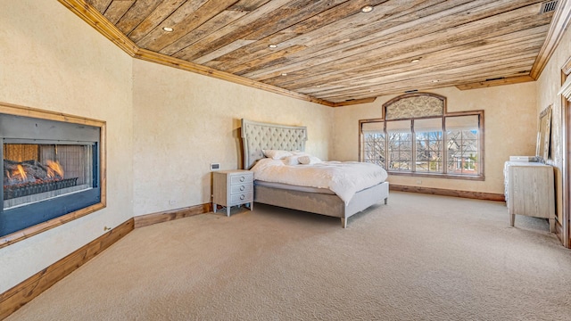 carpeted bedroom with baseboards, wood ceiling, crown molding, and a lit fireplace